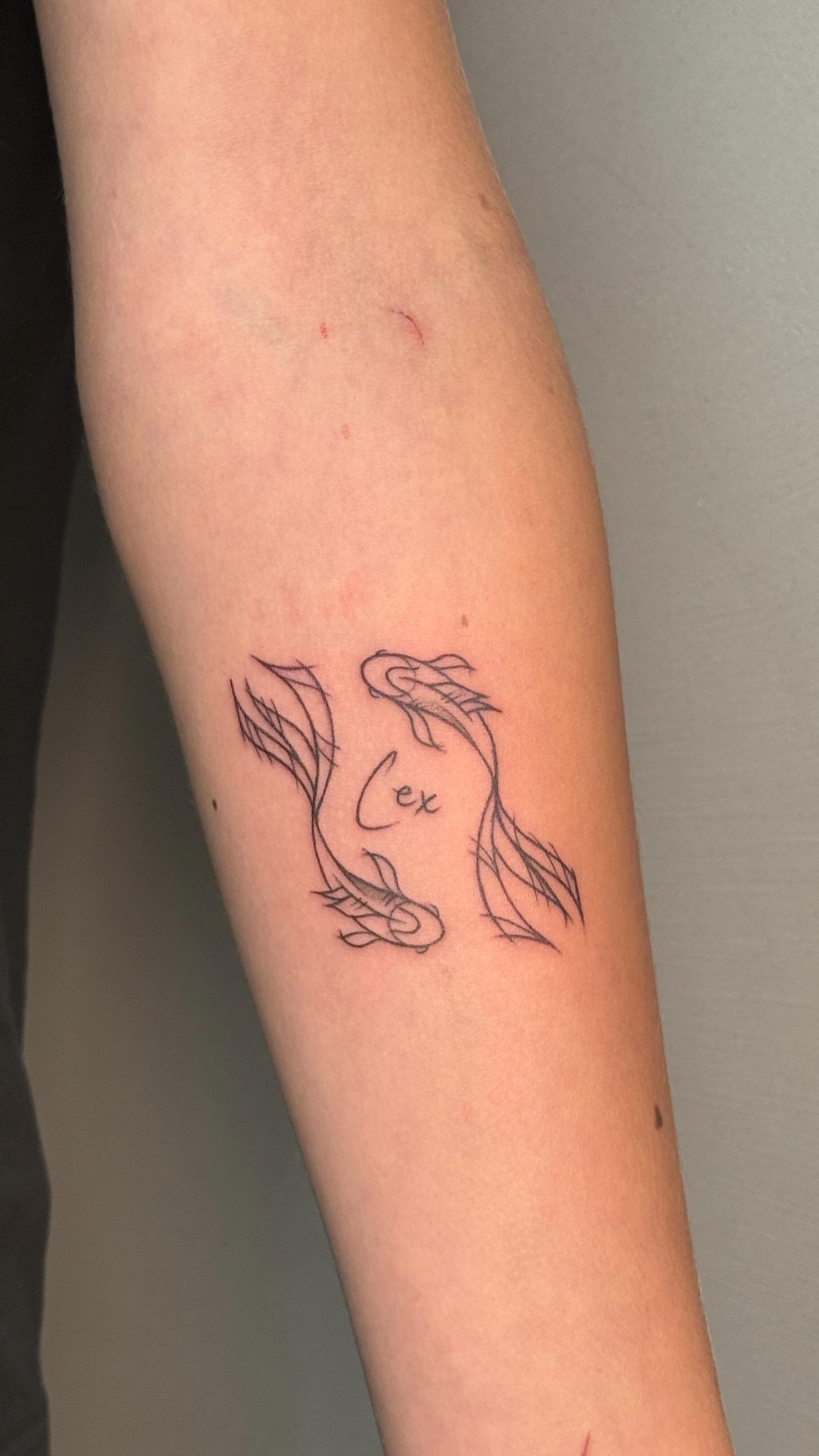Fine line koi op de onderarm